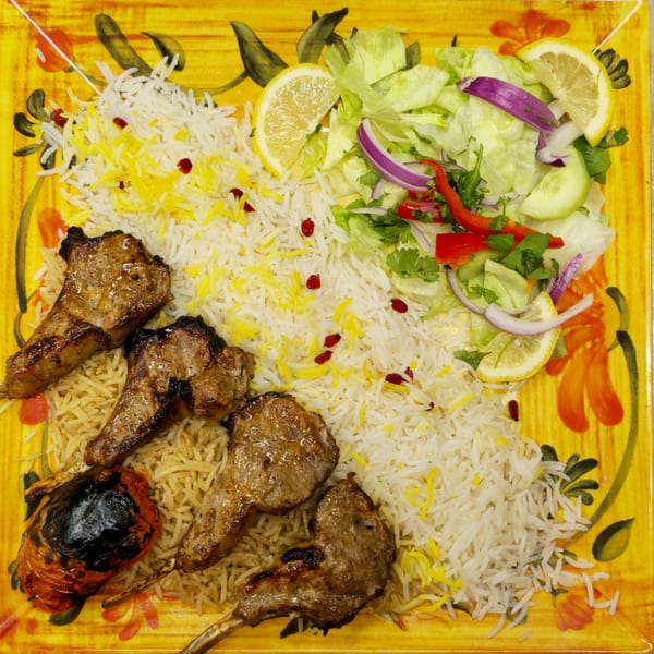 Grub Palace's lamb chops with white and yellow rice, a grilled tomato, and a fresh salad.
