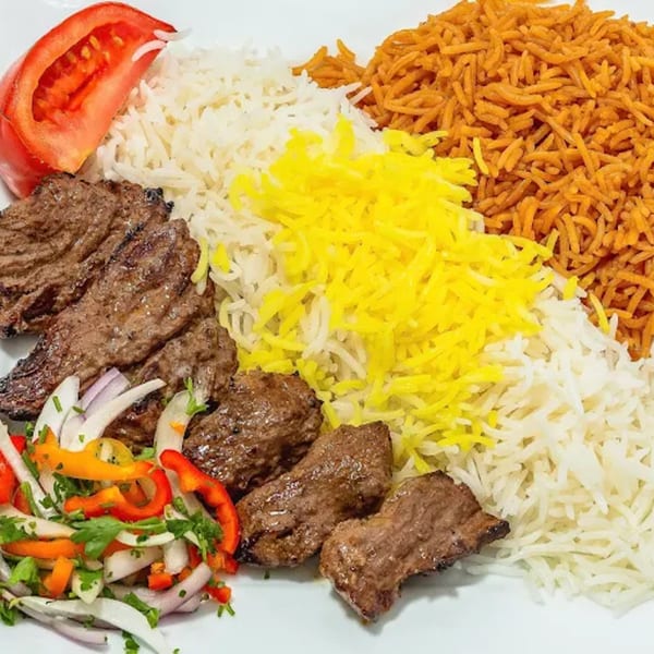Grub Palace's Afghan dish with grilled meat, three types of rice, fresh salad, and a tomato.