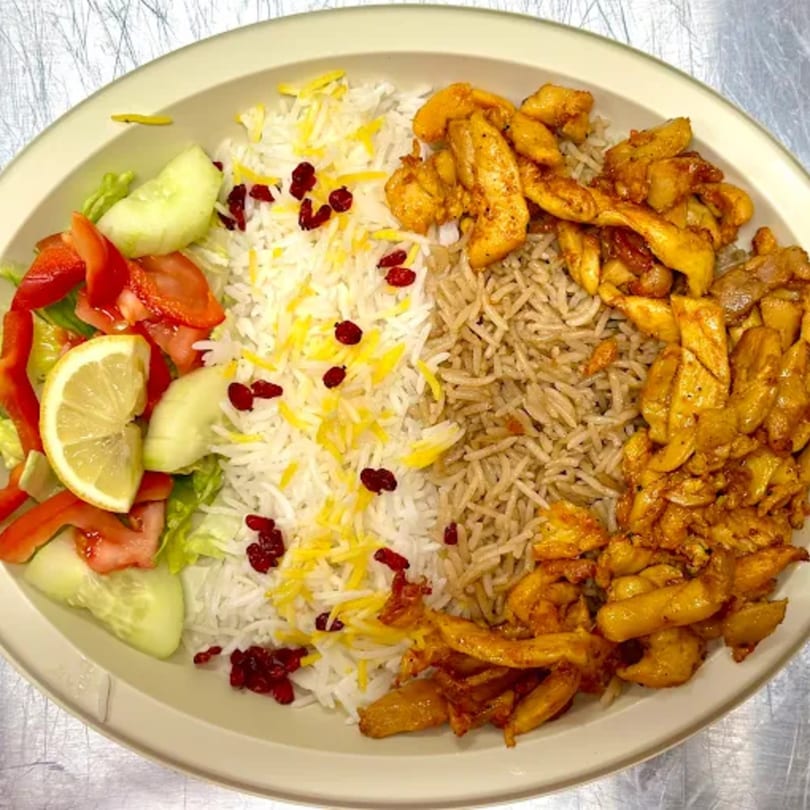 Afghan chicken and rice platter with salad, white rice with barberries, and brown rice.
